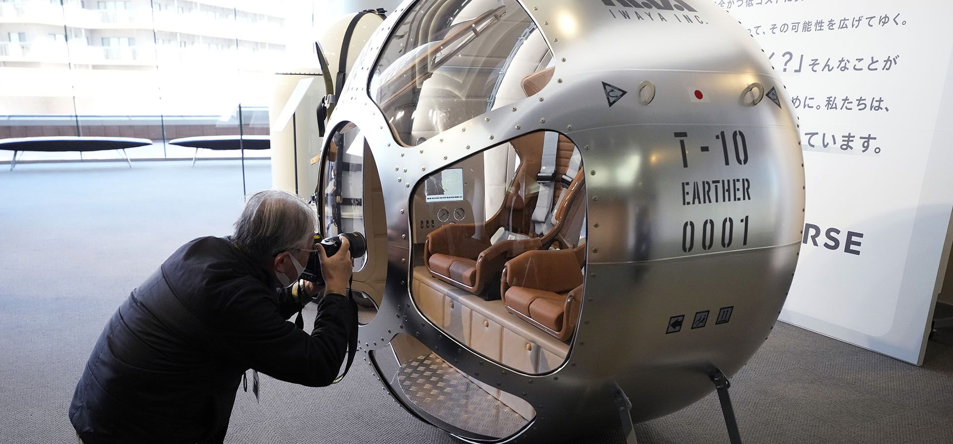 Un periodista fotografía una cabina de dos plazas que, según la empresa fabricante, es capaz de elevarse a una altitud de 15 millas, que es aproximadamente la mitad de la estratosfera, se muestra durante una conferencia de prensa en Tokio, el martes 21 de febrero de 2023. (Foto AP/Eugene Hoshiko)