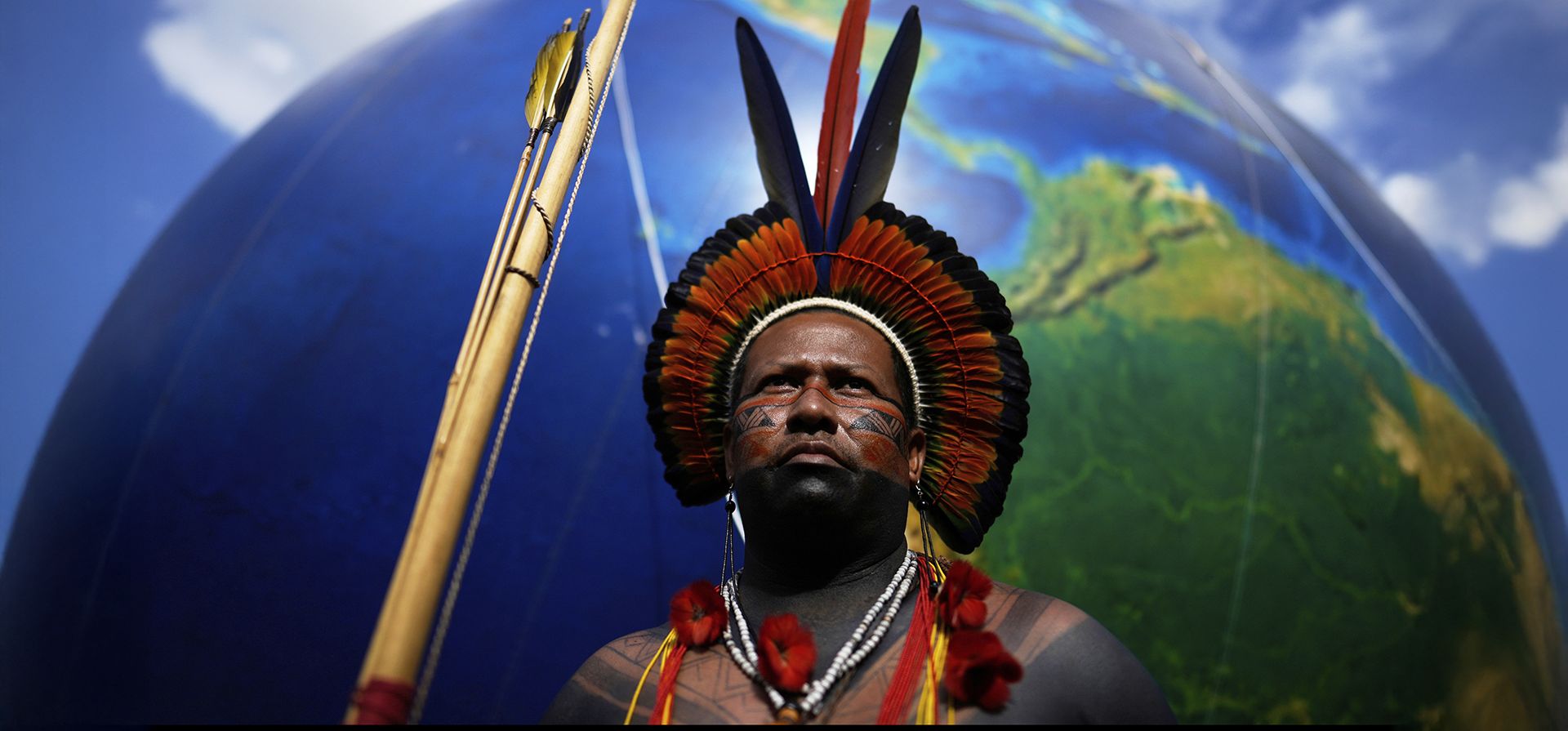 Un indígena, junto a un enorme globo que representa la Tierra, durante la marcha Un indígena, junto a un enorme globo que representa la Tierra, durante la marcha
