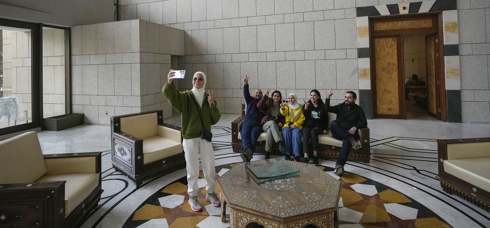 Un grupo de personas se toma una fotografía familiar mientras están sentadas en un sofá en un salón del palacio presidencial del presidente sirio Bashar Assad en Damasco, Siria, el domingo 8 de diciembre de 2024. (Foto AP/Hussein Malla) Un grupo de personas se toma una fotografía familiar mientras están sentadas en un sofá en un salón del palacio presidencial del presidente sirio Bashar Assad en Damasco, Siria, el domingo 8 de diciembre de 2024. (Foto AP/Hussein Malla)