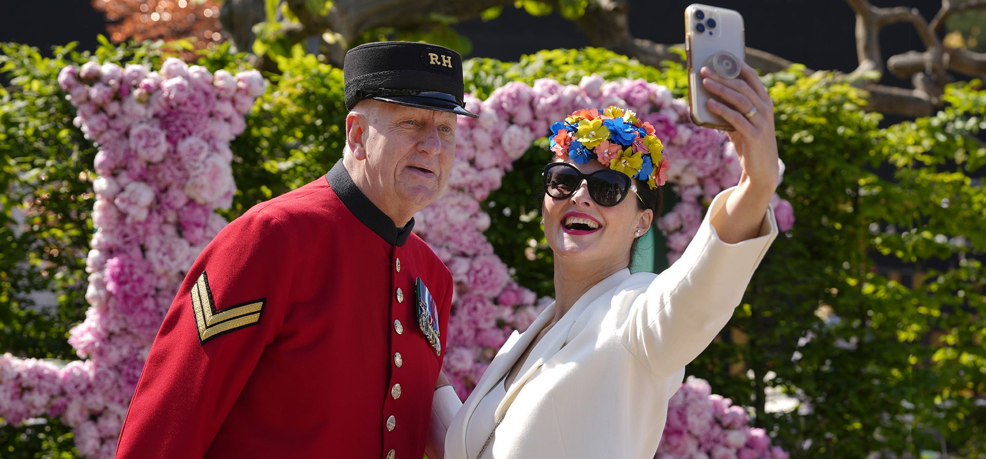 Un visitante con sombreros con temas florales se toma una selfie con el pensionista de Chelsea Norman Bareham en el Chelsea Flower Show en Londres, el lunes 20 de mayo de 2024. El RHS Chelsea Flower Show es el lugar para ver diseños de jardines de vanguardia, nuevas plantas y encontrar ideas para llevar a casa. (Foto AP/Kirsty Wigglesworth) Un visitante con sombreros con temas florales se toma una selfie con el pensionista de Chelsea Norman Bareham en el Chelsea Flower Show en Londres, el lunes 20 de mayo de 2024. El RHS Chelsea Flower Show es el lugar para ver diseños de jardines de vanguardia, nuevas plantas y encontrar ideas para llevar a casa. (Foto AP/Kirsty Wigglesworth)