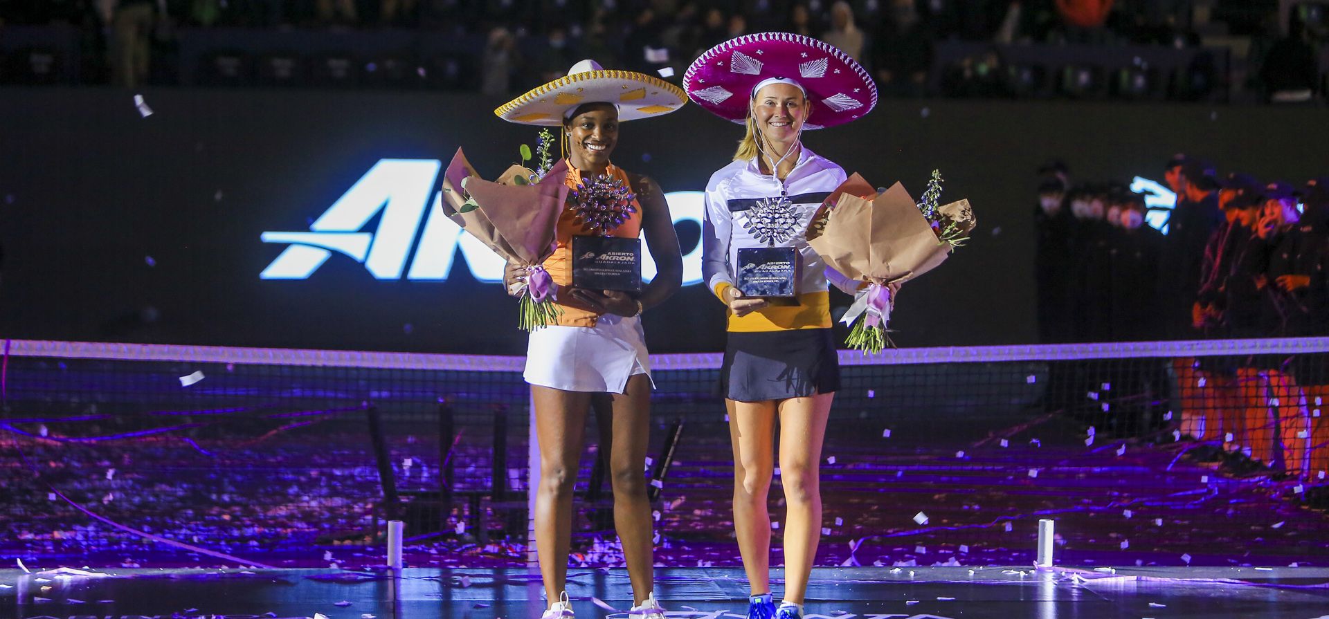 Sloane Stephens, de Estados Unidos, a la izquierda, y Marie Bouzkova, de República Checa, llevan sus trofeos después del partido final del torneo de tenis Abierto de Zapopan en Guadalajara, México, el domingo 27 de febrero de 2022.