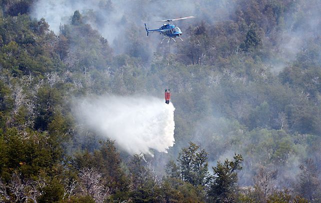 alivio. Un helibalde chileno arroja agua sobre los focos ígneos en Cholila.