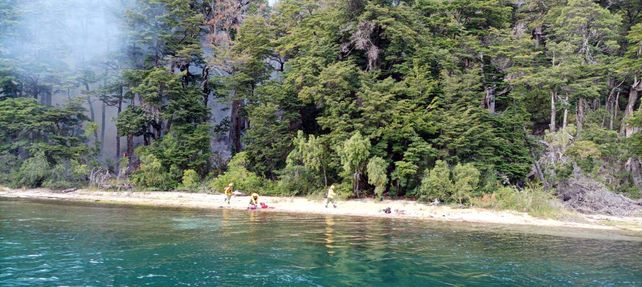 Bomberos en la orilla del lago Nahuel Huapi en el brazo de la Tristeza