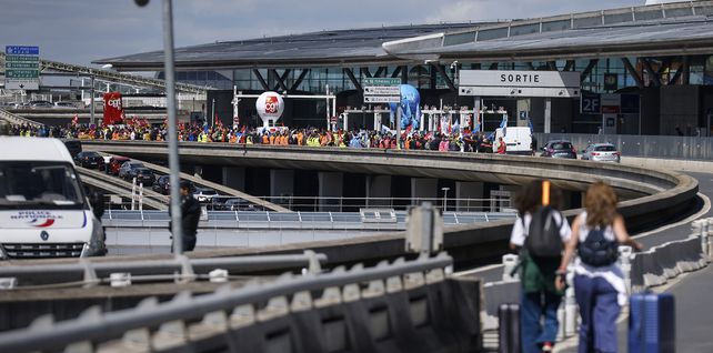 Los viajeros llegan a pie al aeropuerto de Roissy-Charles de Gaulle mientras los trabajadores del aeropuerto realizaron una huelga y protestas para exigir aumentos salariales para mantenerse al día con la inflación