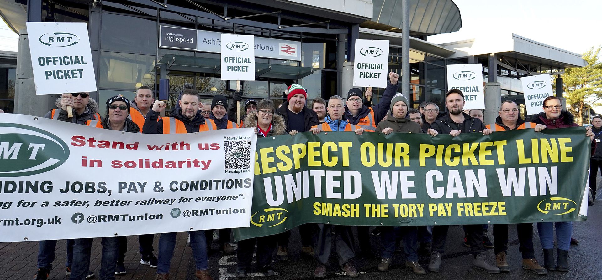 Personal ferroviario afuera se para en la línea de piquete durante una huelga ferroviaria en una disputa de larga data sobre empleos y pensiones, afuera de la estación Ashford International en Kent, Inglaterra, el viernes 6 de enero de 2023. (Gareth Fuller/PA vía AP)
