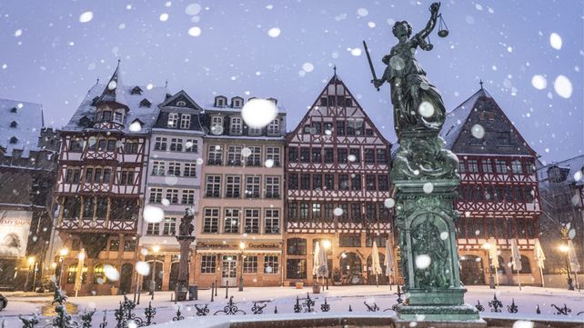 La nieve cae sobre la estatua de la justicia en la plaza Roemerberg