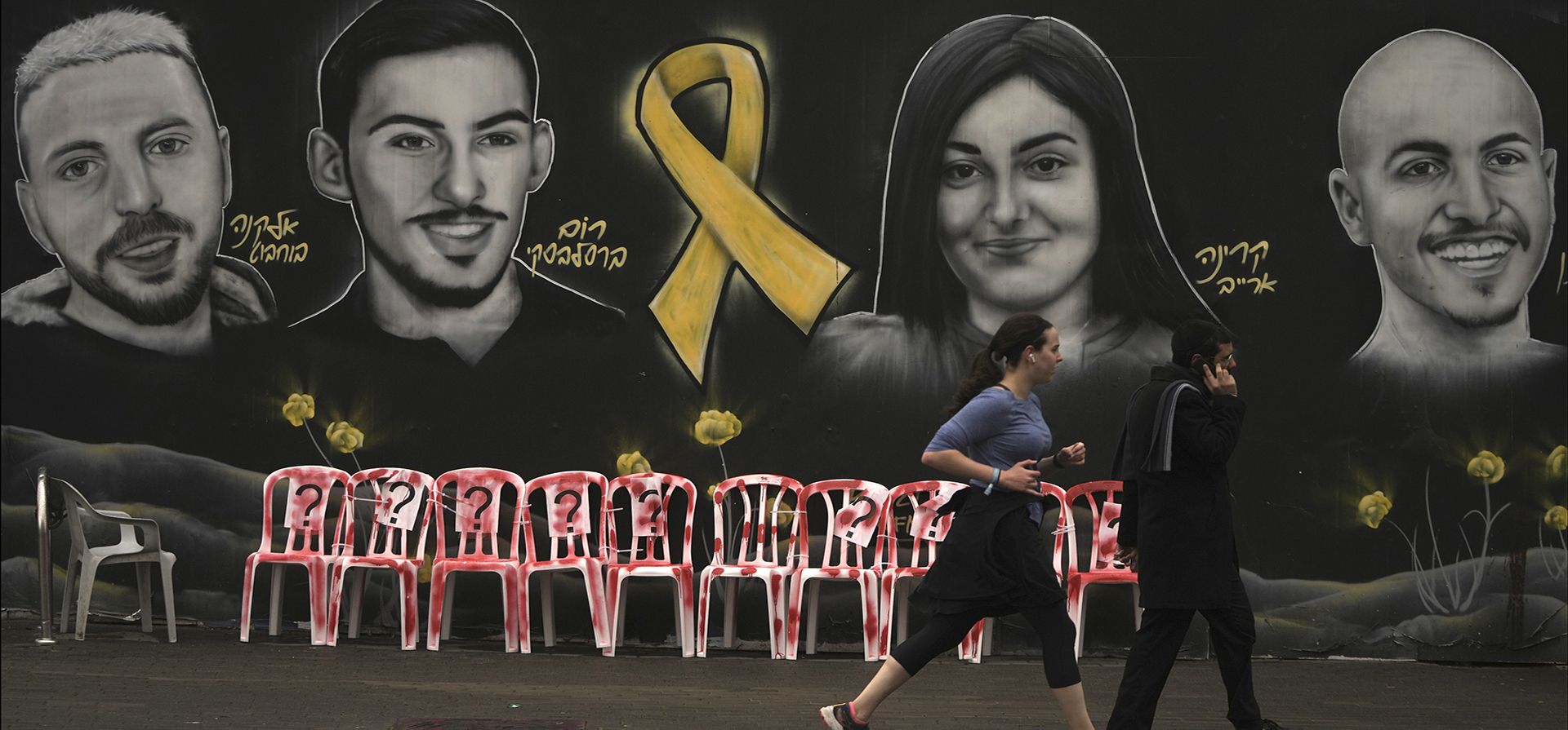 La gente camina y trota frente a una instalación y un mural con retratos de rehenes retenidos por Hamas en la Franja de Gaza, en Jerusalén, el viernes 24 de enero de 2025. (Foto AP/Mahmoud Illean) La gente camina y trota frente a una instalación y un mural con retratos de rehenes retenidos por Hamas en la Franja de Gaza, en Jerusalén, el viernes 24 de enero de 2025. (Foto AP/Mahmoud Illean)