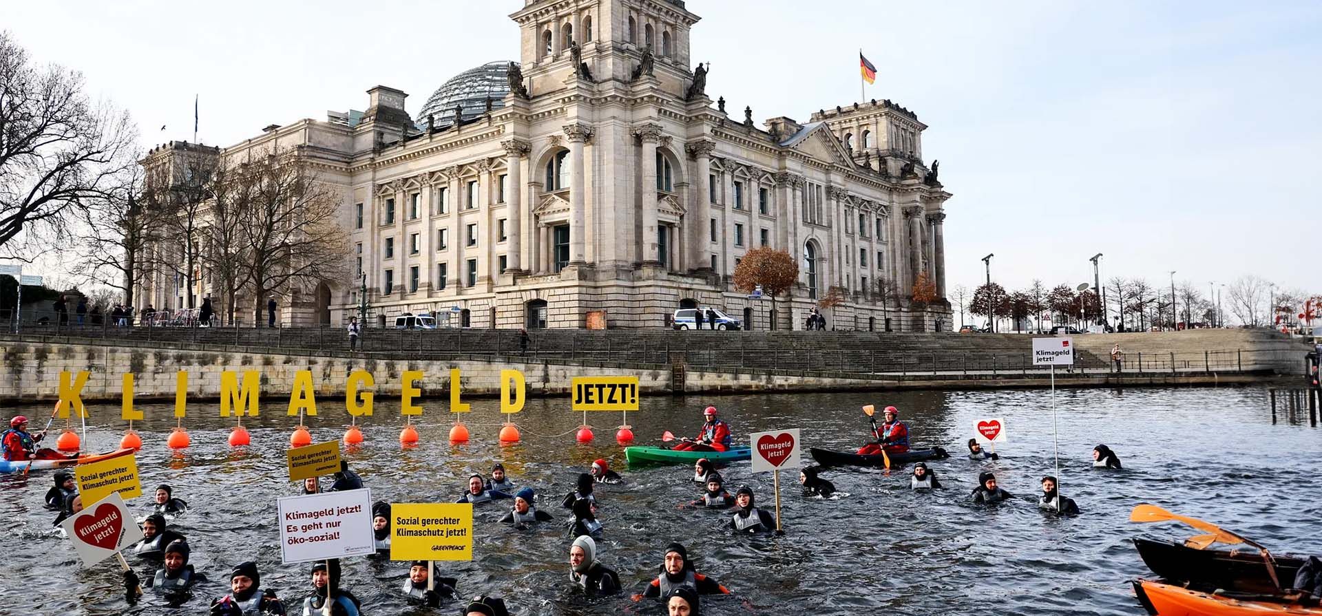 Activistas de Greenpeace nadan con pancartas en el río Spree en una "protesta de baños de hielo por dinero climático" frente al Bundestag mientras el Parlamento celebraba un debate sobre el presupuesto para 2024. Fotografía: Filip Singer/EPA Activistas de Greenpeace nadan con pancartas en el río Spree en una "protesta de baños de hielo por dinero climático" frente al Bundestag mientras el Parlamento celebraba un debate sobre el presupuesto para 2024. Fotografía: Filip Singer/EPA