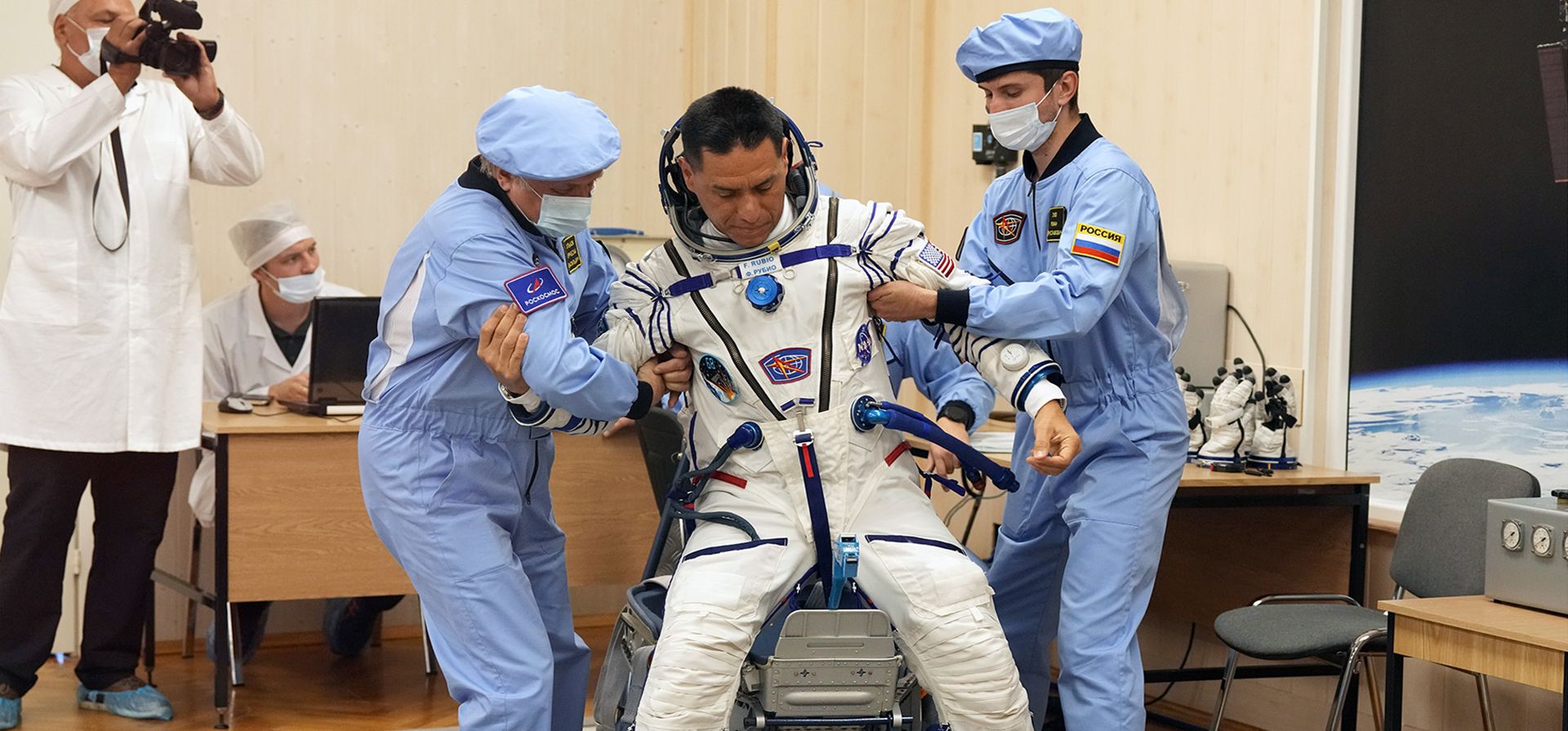Expertos de la Agencia Espacial Rusa ayudan al astronauta de la NASA Frank Rubio, miembro de la tripulación principal de la expedición a la Estación Espacial Internacional (ISS), a ponerse de pie después de inspeccionar su traje espacial antes del lanzamiento de la nave espacial Soyuz MS-22 en el Baikonur alquilado por Rusia.