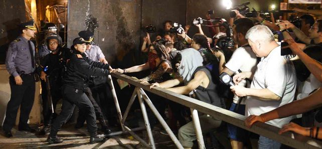 Forcejeos. Un grupo de manifestantes disputa con efectivos policiales mientras intentan correr una de las barandas colocadas sobre uno de los extremos de la iglesia catedral.
