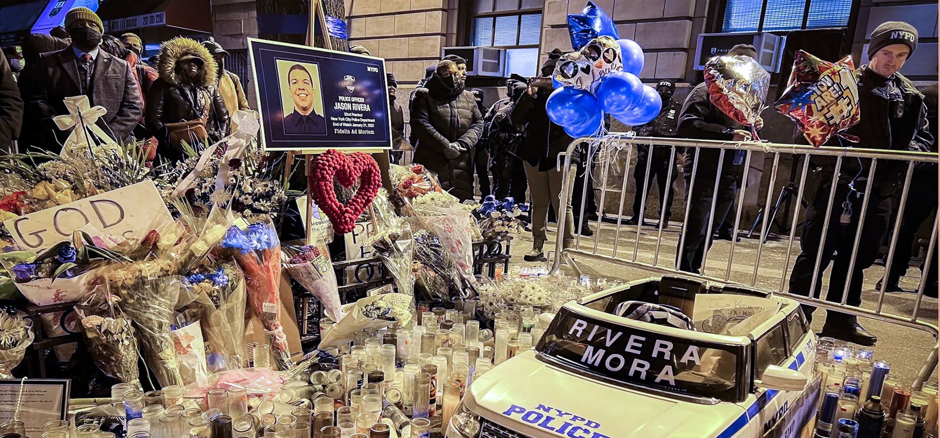 Una vigilia alrededor de un monumento improvisado fuera del distrito 32° en honor a dos oficiales caídos de la policía de Nueva York, Jason Rivera y Wilbert Mora, en Harlem, Nueva York.