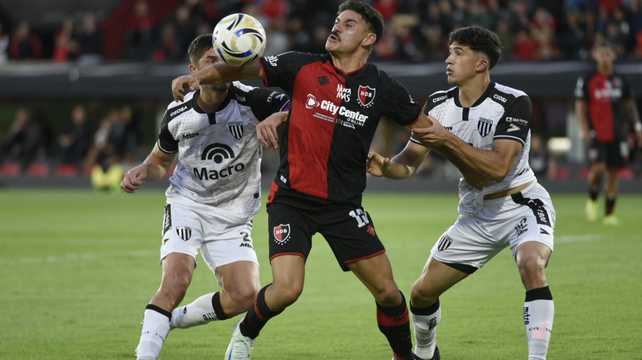 Matías Cóccaro disputa con fuerza la pelota. El nueve de Newells muestra carácter y decisión.