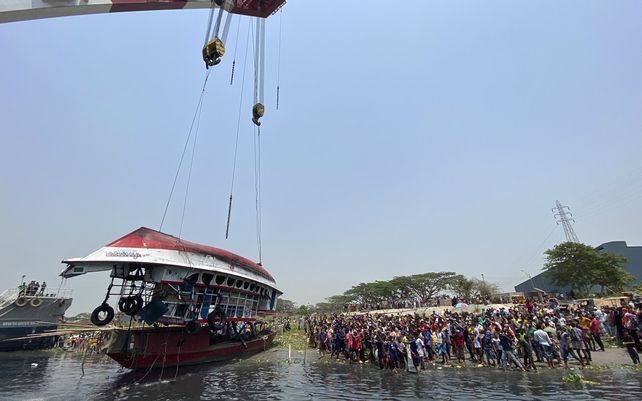 Equipos de rescate sacan un ferry que se hundió el domingo por la noche después de ser golpeado por un buque de carga en el río Shitalakkhya en el distrito de Narayanganj