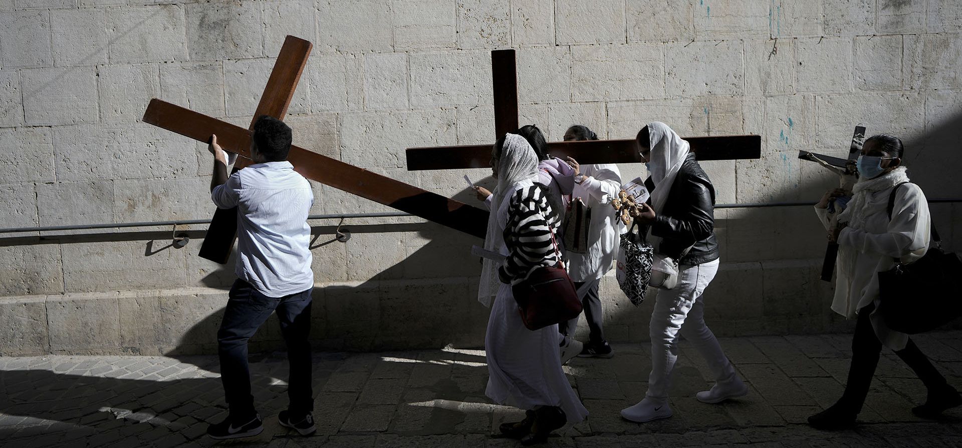 Fieles cristianos llevan una cruz mientras caminan por la Vía Dolorosa hacia la Iglesia del Santo Sepulcro, donde muchos cristianos creen que Jesús fue crucificado, enterrado y resucitado de entre los muertos, durante la procesión del Viernes Santo en la Ciudad Vieja de Jerusalén, el viernes 15 de abril de 2022.