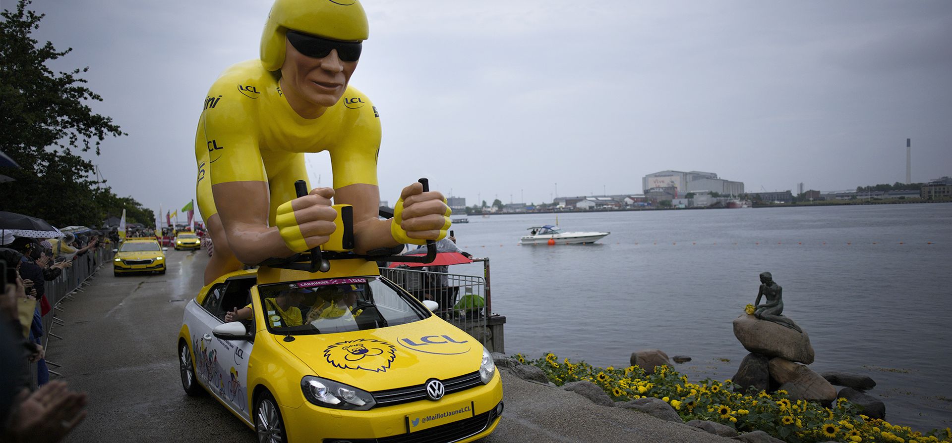 Un ciclista gigante, vestido con el maillot amarillo de líder general, pasa junto a la estatua de la Sirenita de Edvard Eriksen durante el desfile de patrocinadores antes de la primera etapa de la carrera ciclista del Tour de Francia, una contrarreloj individual de 13,2 kilómetros con inicio y finaliza en Copenhague, Dinamarca, el viernes 1 de julio de 2022.