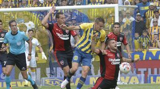 Marco Ruben forcejea con Julián Fernández, mientras Cristian Lema sigue la acción de muy cerca. Central fue nuevamente un mar de dudas en cancha.