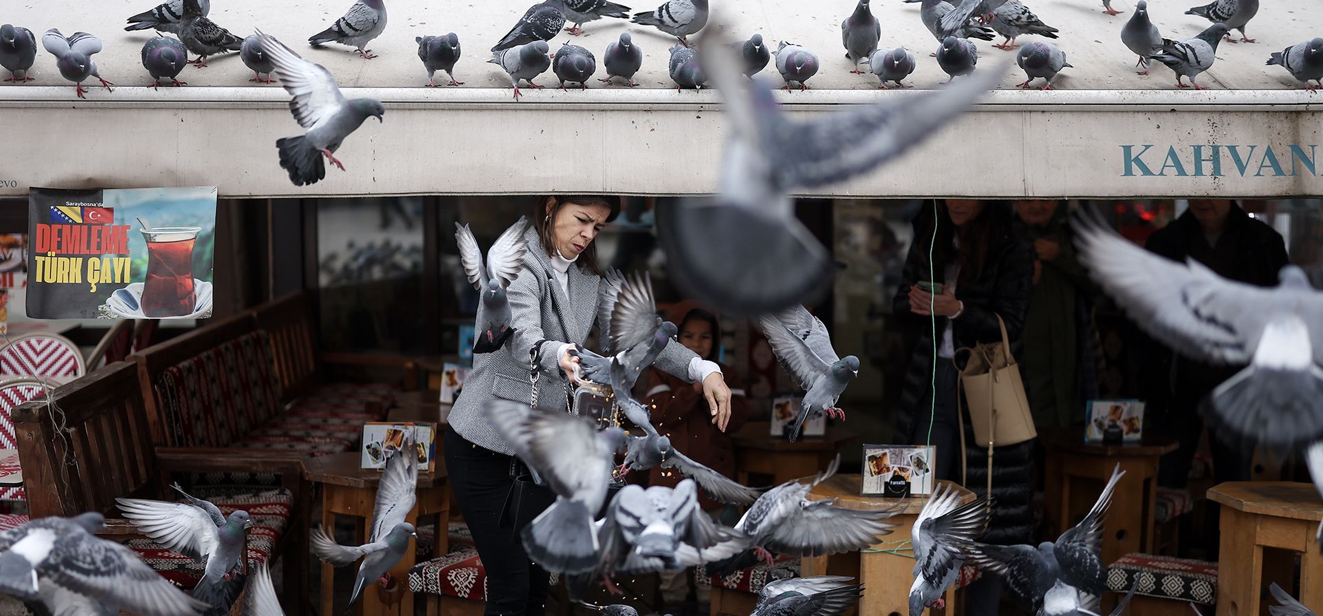 Una mujer se esconde de las palomas mientras les lanza maíz para alimentarlas en la parte antigua de Sarajevo, Bosnia, el miércoles 19 de noviembre de 2025. (Foto AP/Armin Durgut) Una mujer se esconde de las palomas mientras les lanza maíz para alimentarlas en la parte antigua de Sarajevo, Bosnia, el miércoles 19 de noviembre de 2025. (Foto AP/Armin Durgut)