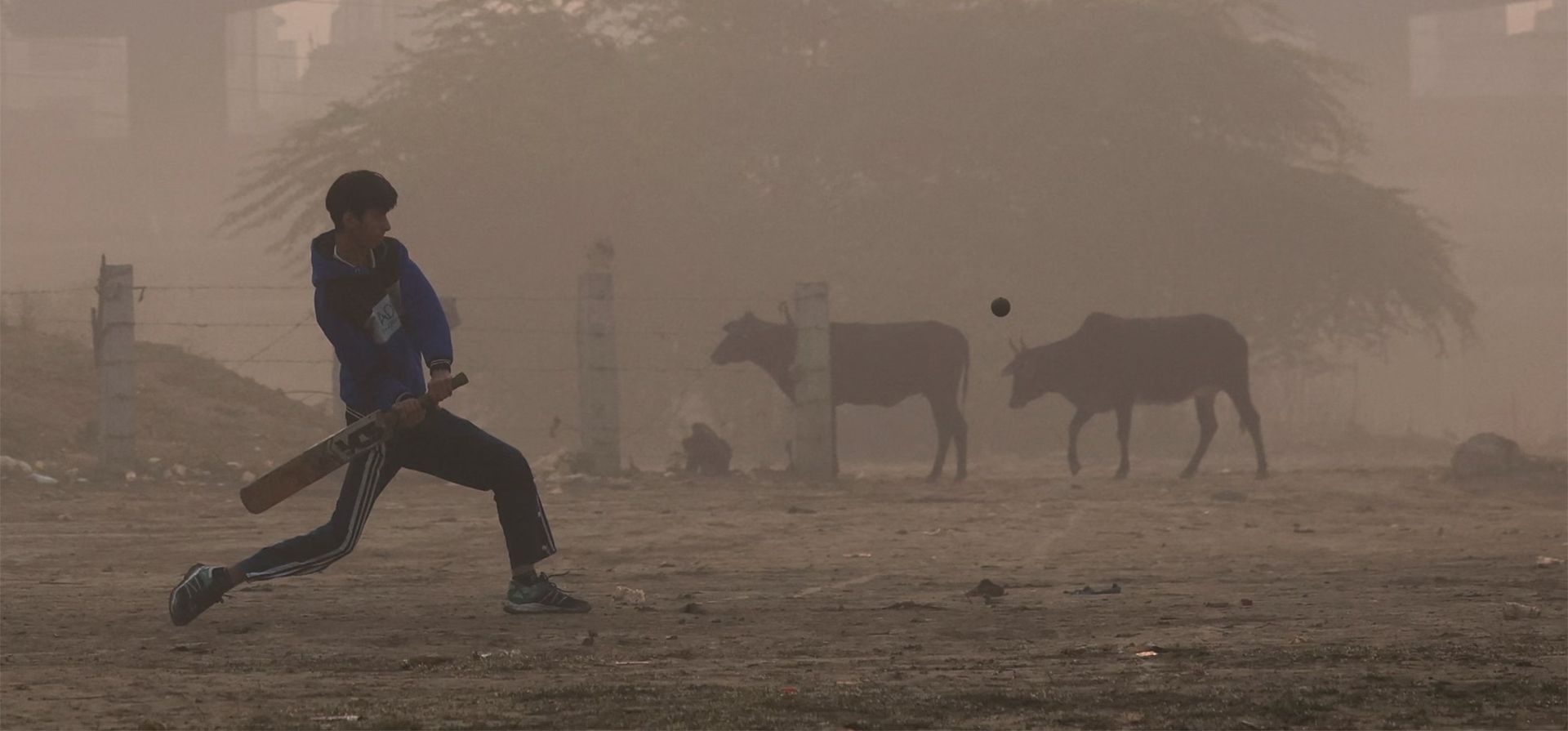 Un niño juega al cricket cerca de las orillas del río Yamuna en una mañana llena de smog, Nueva Delhi, India. Fotografía: Anushree Fadnavis/Reuters Un niño juega al cricket cerca de las orillas del río Yamuna en una mañana llena de smog, Nueva Delhi, India. Fotografía: Anushree Fadnavis/Reuters