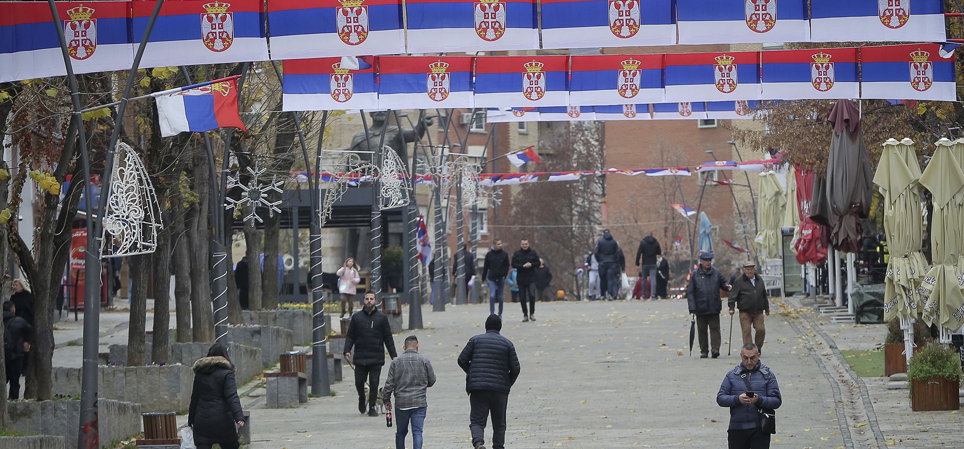 Banderas nacionales serbias decoran la plaza principal en una ciudad étnicamente dividida dominada por los serbios en el norte de Mitrovica el viernes 9 de diciembre de 2022. Las fuerzas del orden de Kosovo dijeron el viernes que un oficial resultó herido por hombres armados después de aumentar la presencia policial por temor a la tensión en las áreas del norte dominadas por la etnia serbia minoría. (Foto AP/Visar Kryeziu)