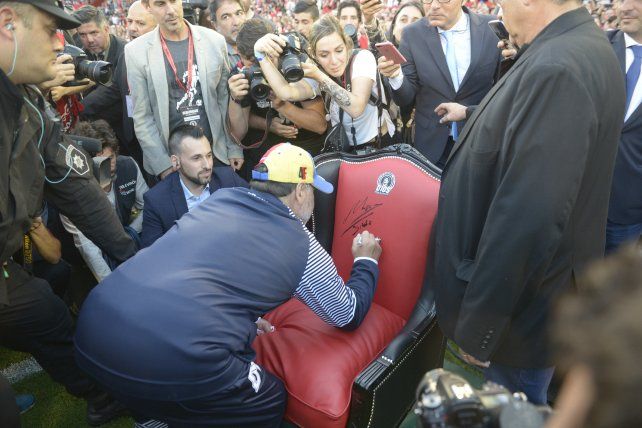 El trono. Maradona firma el sillón que le obsequió Newell’s. 