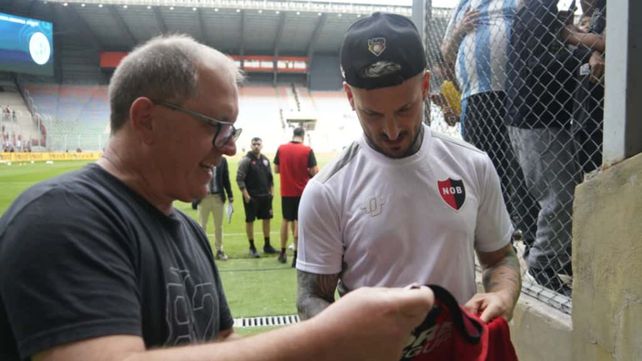 Darío Benedetto firma una camiseta de Newells que le dieron los hinchas en la boca de acceso al vestuario. El Pipa será titular.