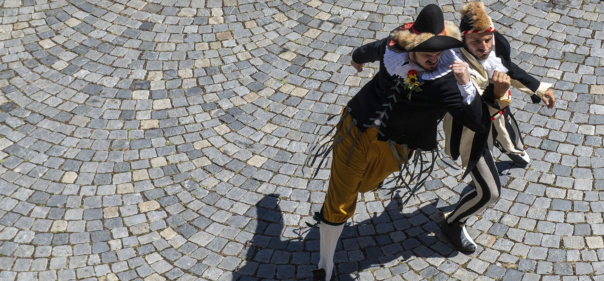 Miembros del gremio de pescadores del Danubio bailan con trajes históricos en el patio del vino durante un llamado evento tradicional Fischerstechen en Ulm, Alemania, el lunes 18 de julio de 2022.