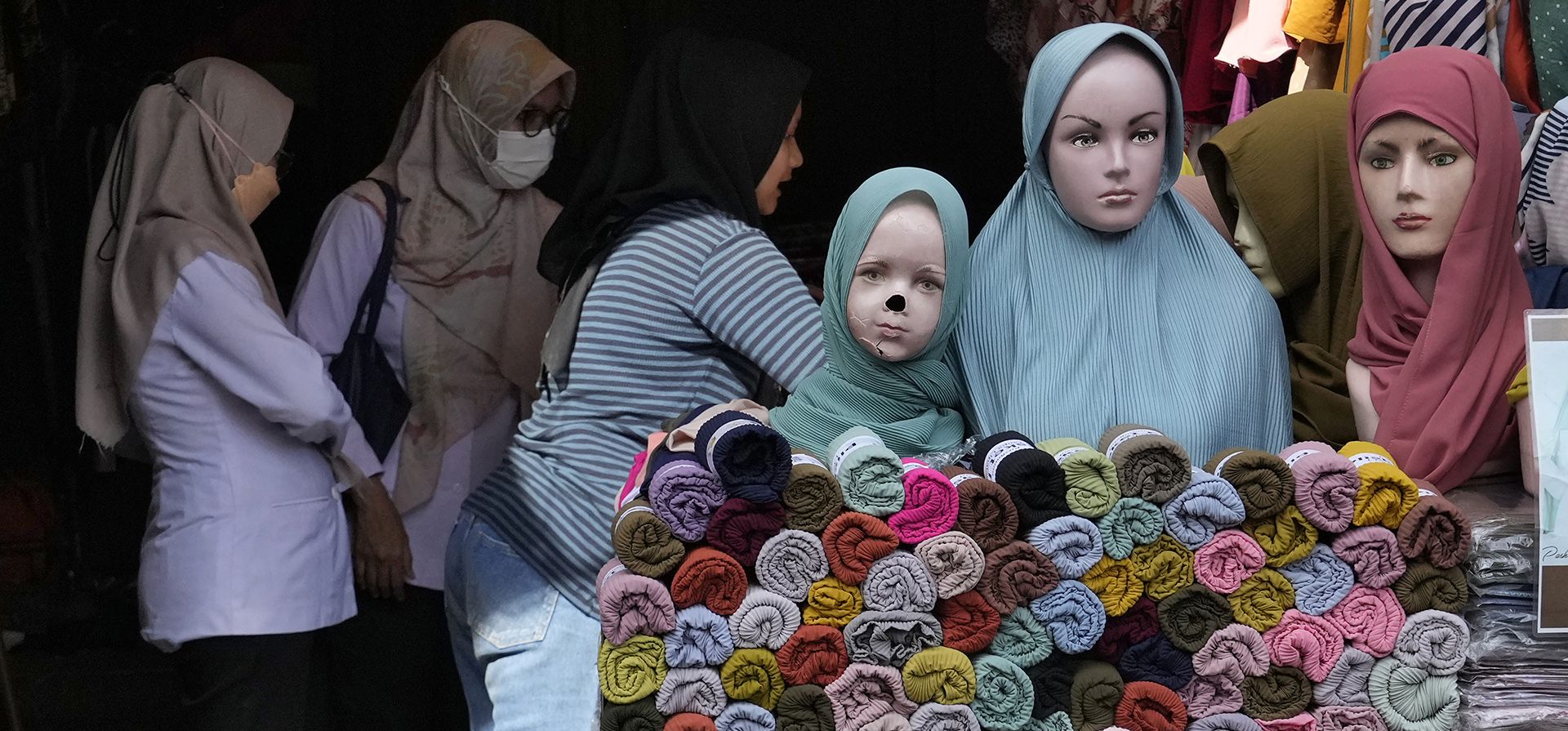 Mujeres compran ropa musulmana durante la última semana del Ramadán en un mercado en Yakarta, Indonesia, el martes 26 de abril de 2022. Las personas acuden en masa a los mercados y centros comerciales en la ciudad capital mientras compran alimentos y ropa nueva en preparación para Eid al Fitr feriado la próxima semana que marca el final del mes más sagrado en el calendario islámico.