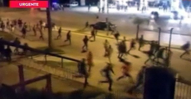 desbande. Los concurrentes huyen de la fiesta entre las balas por las calles de Moreno