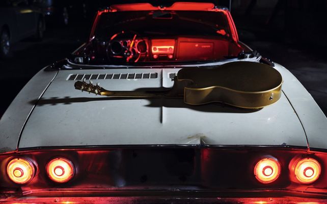Una guitarra —instrumento directamente ligado a la música de Bryan Adams— sobre un capó de un coche conforma la estampa que cierra el almanaque en el mes de diciembre.