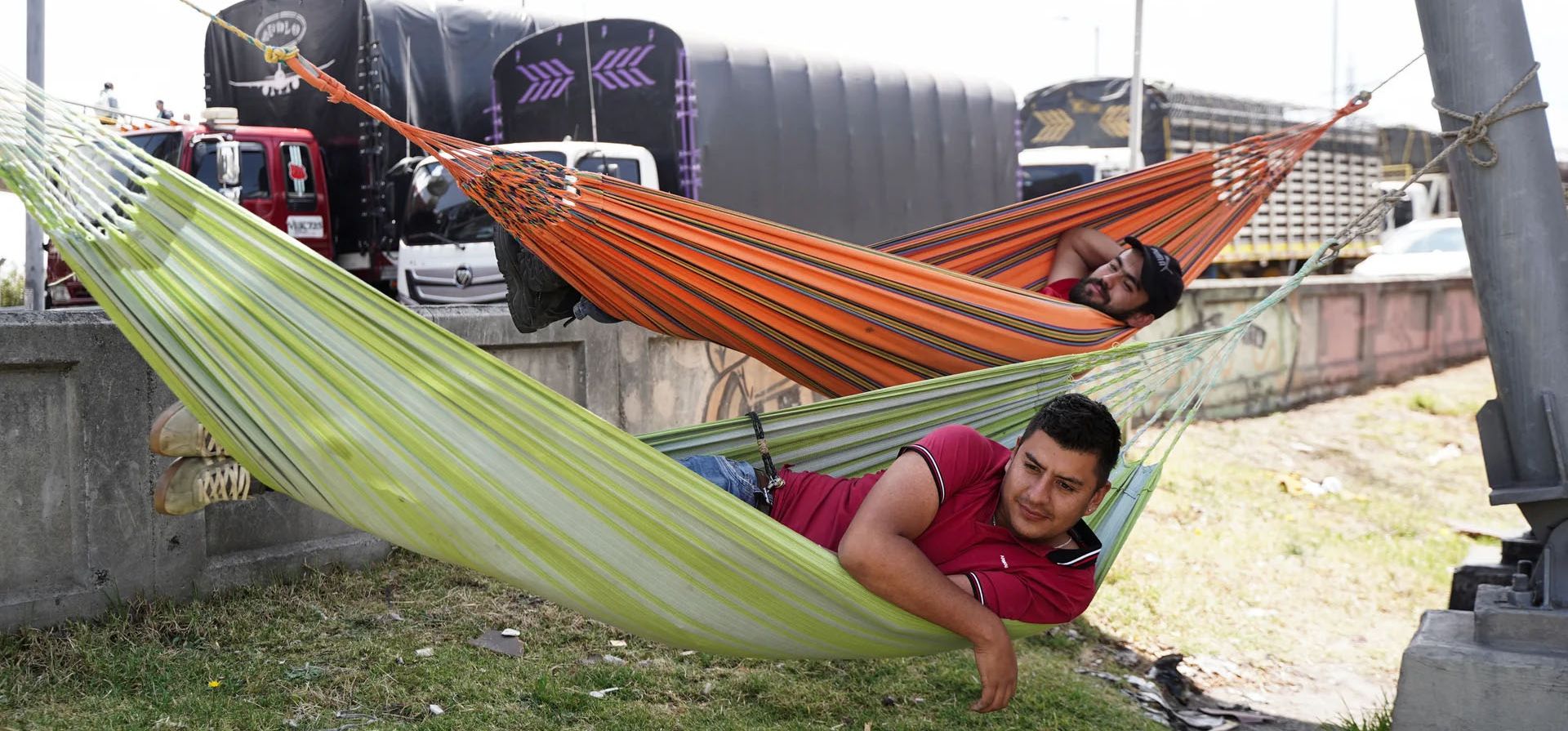 Camioneros descansan en hamacas durante un bloqueo en protesta por el aumento del precio del diésel, Bogotá, Colombia. Fotografía: Nathalia Angarita/Reuters Camioneros descansan en hamacas durante un bloqueo en protesta por el aumento del precio del diésel, Bogotá, Colombia. Fotografía: Nathalia Angarita/Reuters