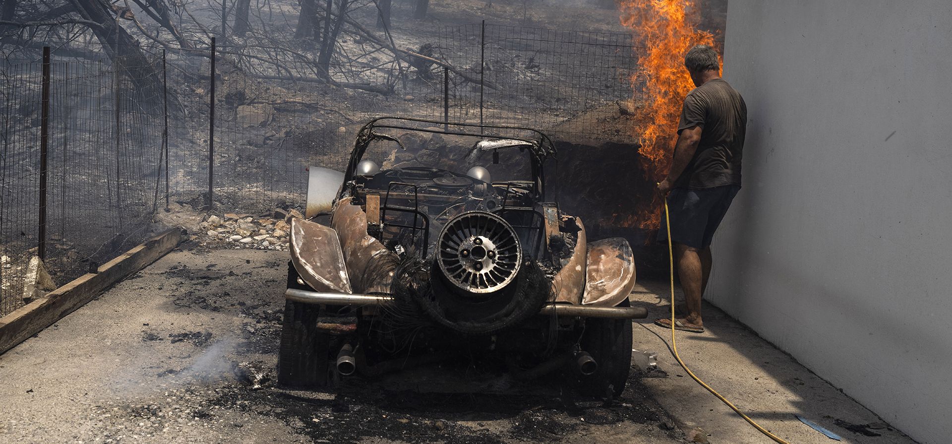 Un residente intenta extinguir las llamas en el patio de una casa en la isla de Rodas, en el sureste de Grecia, en el mar Egeo, el lunes 24 de julio de 2023. (Foto AP/Petros Giannakouris) Un residente intenta extinguir las llamas en el patio de una casa en la isla de Rodas, en el sureste de Grecia, en el mar Egeo, el lunes 24 de julio de 2023. (Foto AP/Petros Giannakouris)