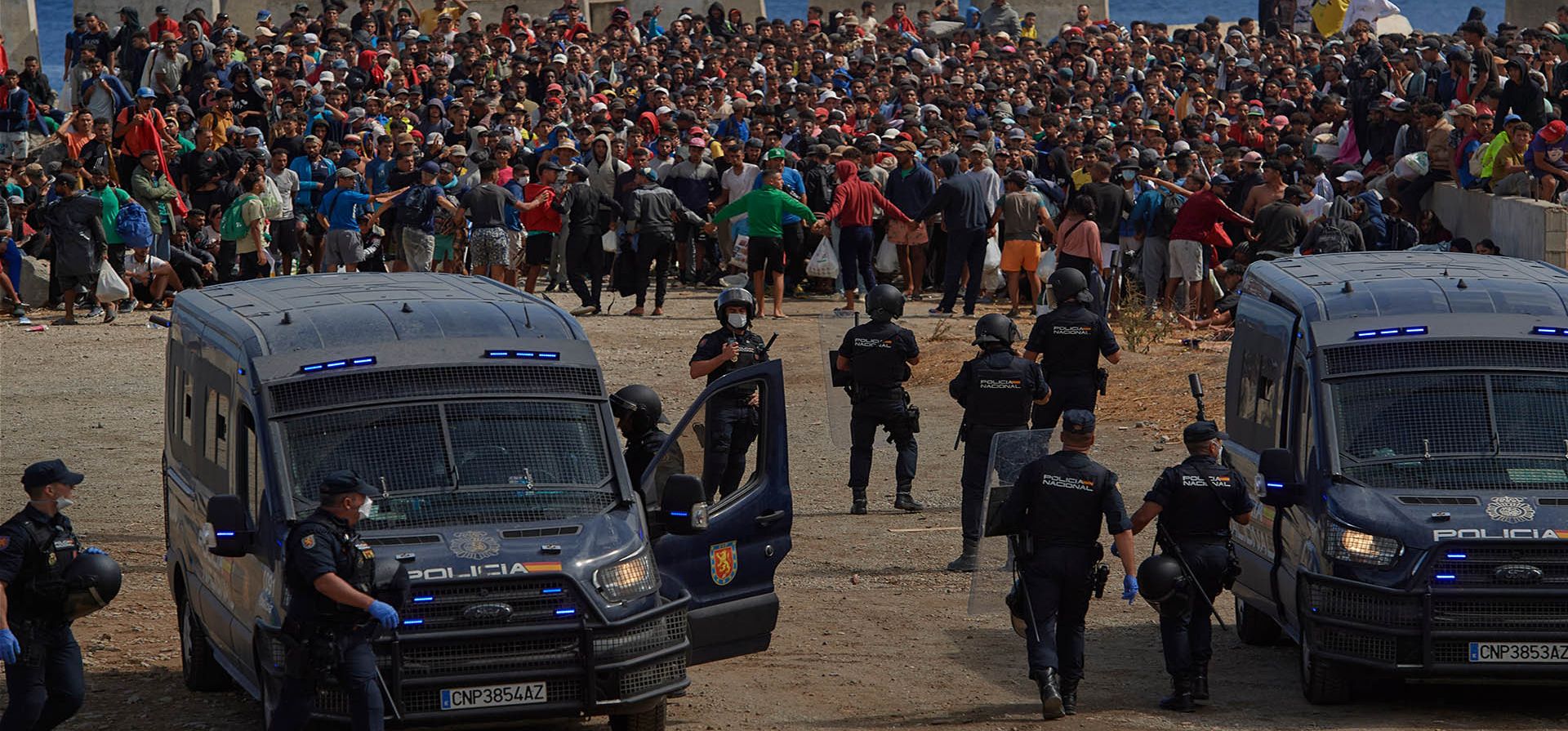 Migrantes que cruzaron de Marruecos a España regresan a una playa tras haber sido expulsados de la zona el día anterior, mientras la policía española los escolta en el enclave español de Ceuta, el viernes 21 de agosto de 2026. (Foto AP/Antonio Sempere) Migrantes que cruzaron de Marruecos a España regresan a una playa tras haber sido expulsados de la zona el día anterior, mientras la policía española los escolta en el enclave español de Ceuta, el viernes 21 de agosto de 2026. (Foto AP/Antonio Sempere)