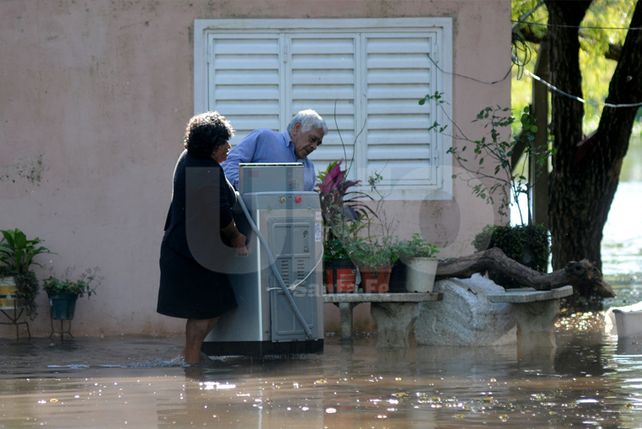 Vecinos de la Vuelta del Paraguayo intentan resguardar sus pertenencias ante la crecida del Paraná.