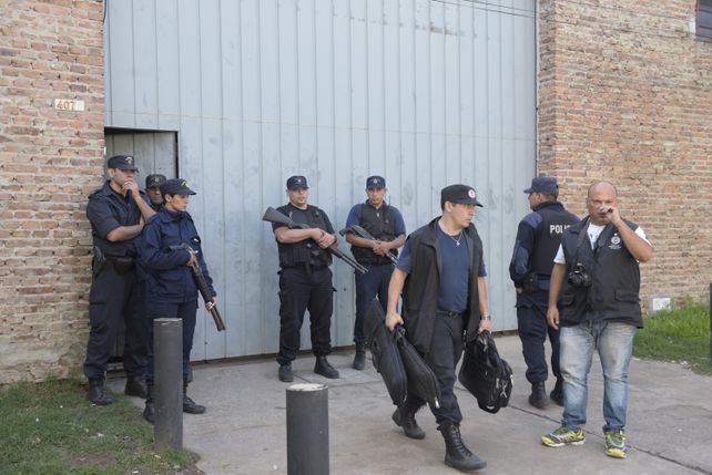 Evidencia. Un oficial de la Policía de Investigaciones se lleva la escopeta con la que le dispararon a Nahuel Navarro. (Silvina Salinas / La Capital)