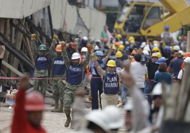 tensión. Los rescatistas de la Marina hacen el gesto de silencio entre las ruinas de la escuela donde se creía que estaba Frida.
