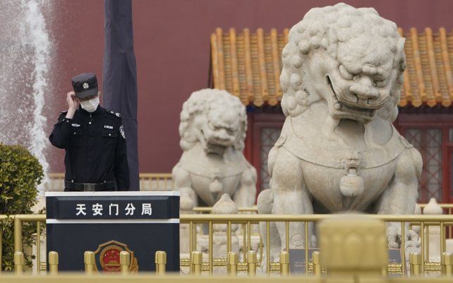 Un oficial de policía chino monta guardia cerca de leones de piedra frente a la Puerta de Tiananmen mientras la sesión de clausura se lleva a cabo en el Gran Salón del Pueblo para el Congreso Nacional del Pueblo en Beijing.