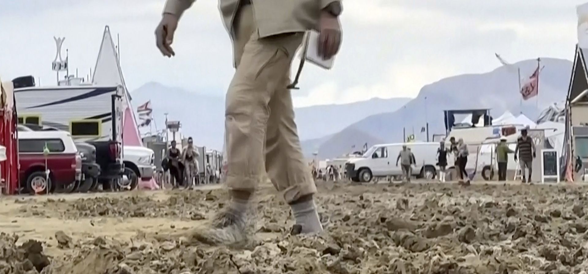 Imagen de un video proporcionado por Stringr, un hombre camina sobre el barro en el sitio del festival Burning Man en Black Rock, Nevada, el lunes 4 de septiembre de 2023. Un retraso inusual -La tormenta de verano dejó varados a miles de personas en el evento de una semana de duración. (Cadena vía AP) Imagen de un video proporcionado por Stringr, un hombre camina sobre el barro en el sitio del festival Burning Man en Black Rock, Nevada, el lunes 4 de septiembre de 2023. Un retraso inusual -La tormenta de verano dejó varados a miles de personas en el evento de una semana de duración. (Cadena vía AP)
