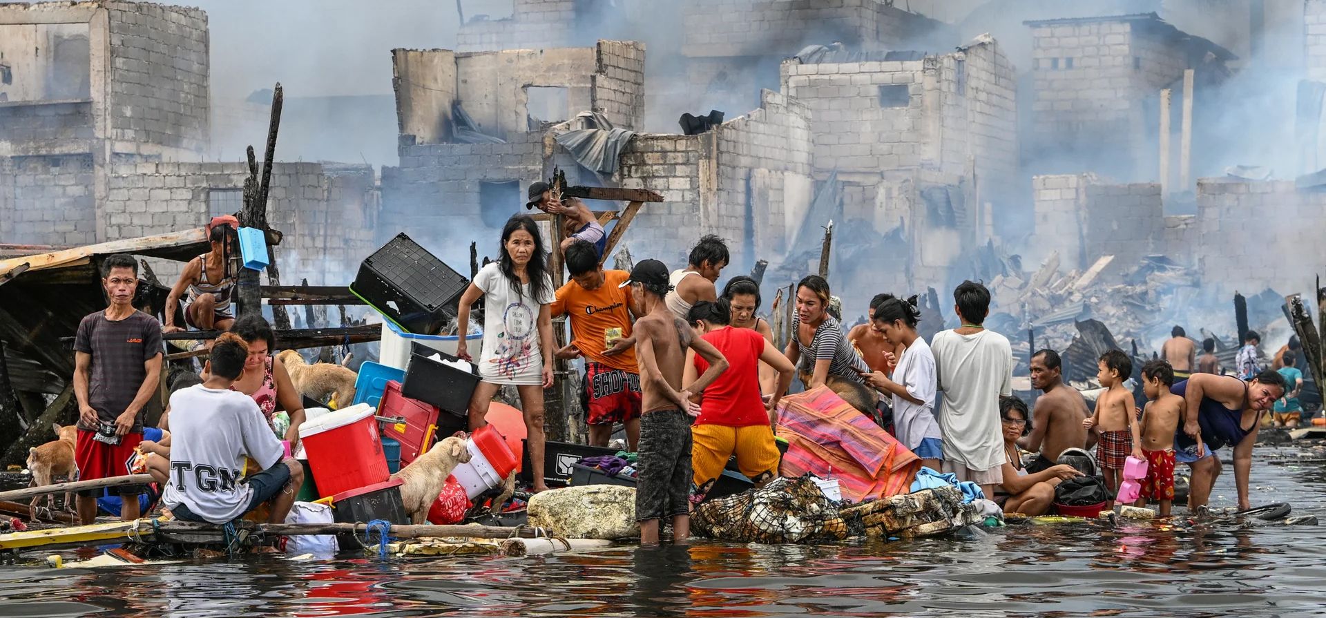 La gente lleva sus pertenencias en una balsa improvisada después de que un incendio arrasara cientos de casas en una zona marginal, Manila, Filipinas. Fotografía: Jam Sta Rosa/AFP/Getty Images La gente lleva sus pertenencias en una balsa improvisada después de que un incendio arrasara cientos de casas en una zona marginal, Manila, Filipinas. Fotografía: Jam Sta Rosa/AFP/Getty Images