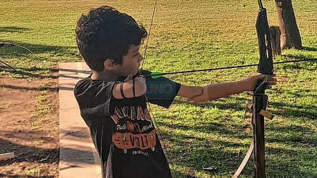 En acción. Santino usa un bracito ortopédico del lado izquierdo para ayudarse a sostener el arco y mantiene con el derecho la puntería de su flecha.