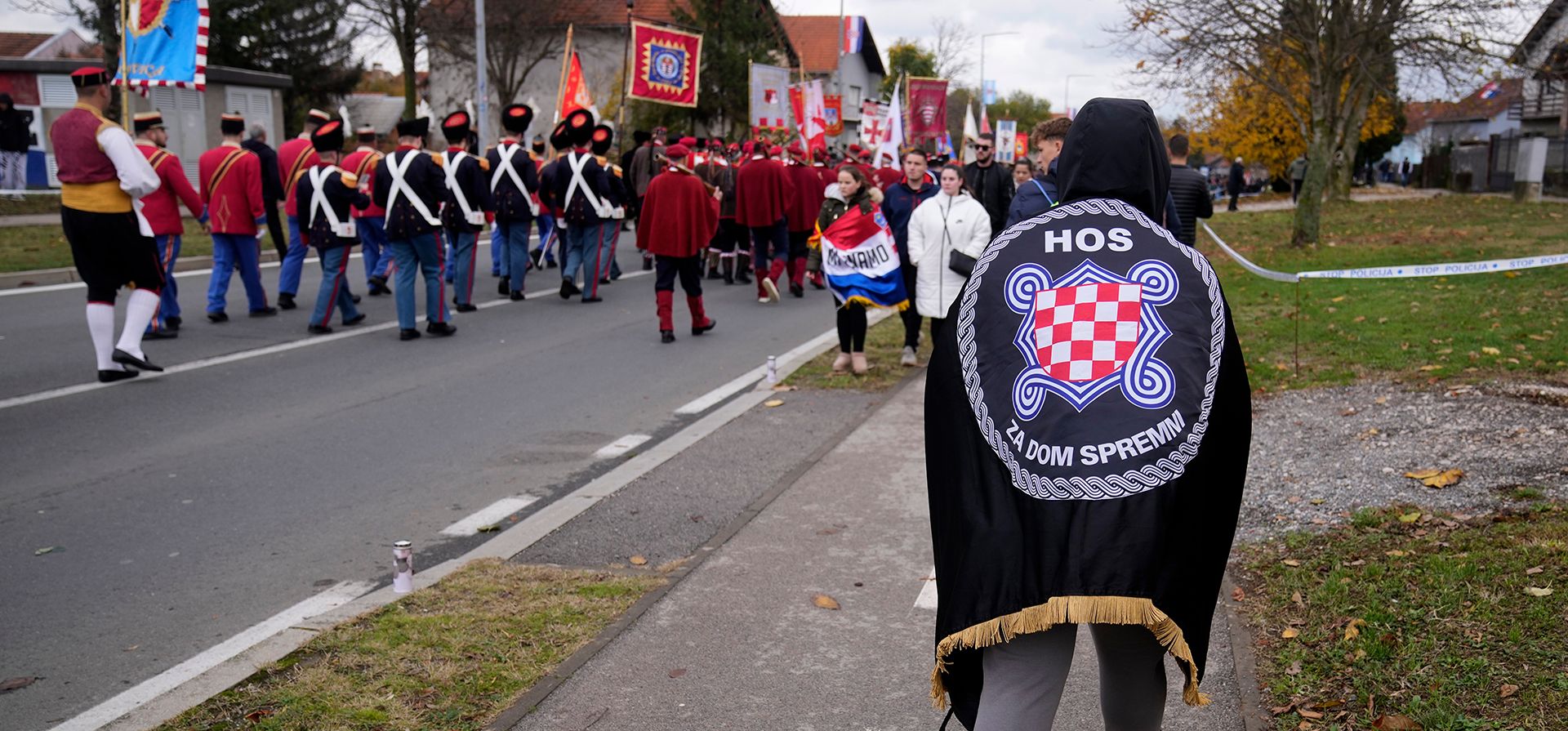 Una persona envuelta en insignias de la derecha participa en una procesión que conmemora el aniversario de la caída de la ciudad durante la guerra de 1991-95, cuando fue prácticamente demolida por las tropas del ejército yugoslavo liderado por los serbios tras un asedio de 87 días, en Vukovar, al este de Croacia, el martes 18 de noviembre de 2025. (Foto AP/Darko Bandic) Una persona envuelta en insignias de la derecha participa en una procesión que conmemora el aniversario de la caída de la ciudad durante la guerra de 1991-95, cuando fue prácticamente demolida por las tropas del ejército yugoslavo liderado por los serbios tras un asedio de 87 días, en Vukovar, al este de Croacia, el martes 18 de noviembre de 2025. (Foto AP/Darko Bandic)