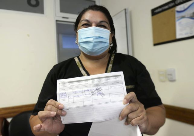 Una agente sanitaria exhibe el certificado de vacunación.&nbsp;