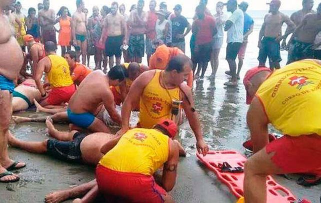 Penoso. Rescatistas tratan de auxiliar a uno de los bañistas afectados por la descarga eléctrica de Praia Grande.