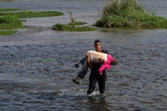 Drama en el río Bravo, que separa a México de Texas. Un joven venezolano lleva en brazos, inconsciente, a una anciana. Los dos escaparon de Venezuela.