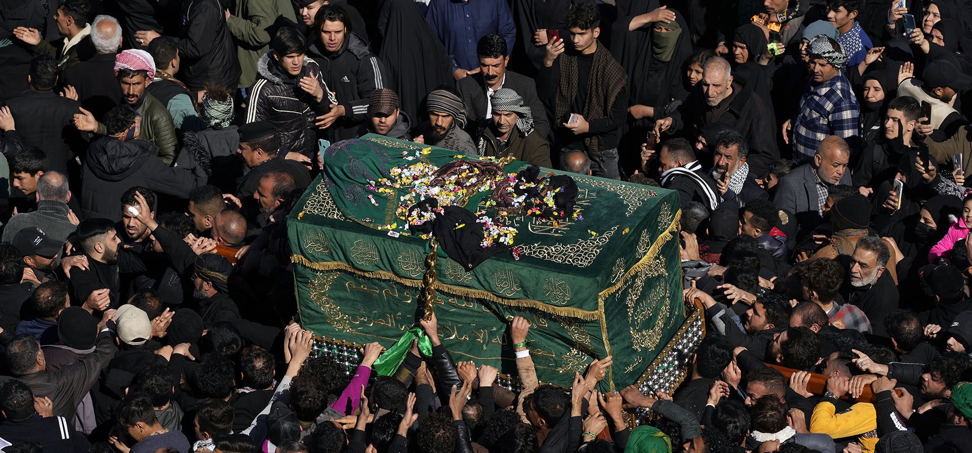 Los fieles chiítas llevan un ataúd simbólico en el santuario de cúpula dorada del imán Moussa al-Kadhim, quien murió a fines del siglo VIII, durante la conmemoración anual de su muerte en Bagdad, Irak, el viernes 17 de febrero de 2023. (Foto AP/Hadi Mizban)