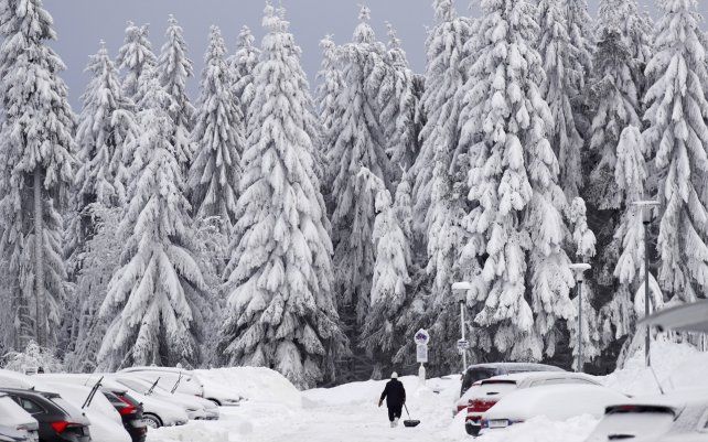 Una mujer quita la nieve frente a su casa después de una fuerte nevada en Oberhof, Alemania. Los meteorólogos predicen que la ola de frío que afecta a gran parte de la región continuará.