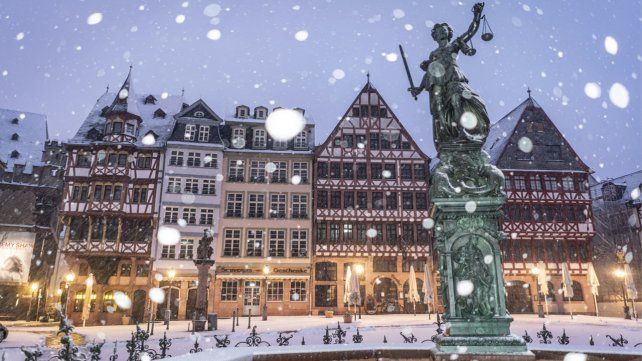 La nieve cae sobre la estatua de la justicia en la plaza Roemerberg, en un día con temperaturas bajo 0°, Frankfurt, Alemania.