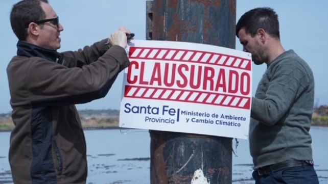 Personal del Ministerio de Medio Ambiente provincial coloca las fajas de clausura en el basural clandestino.