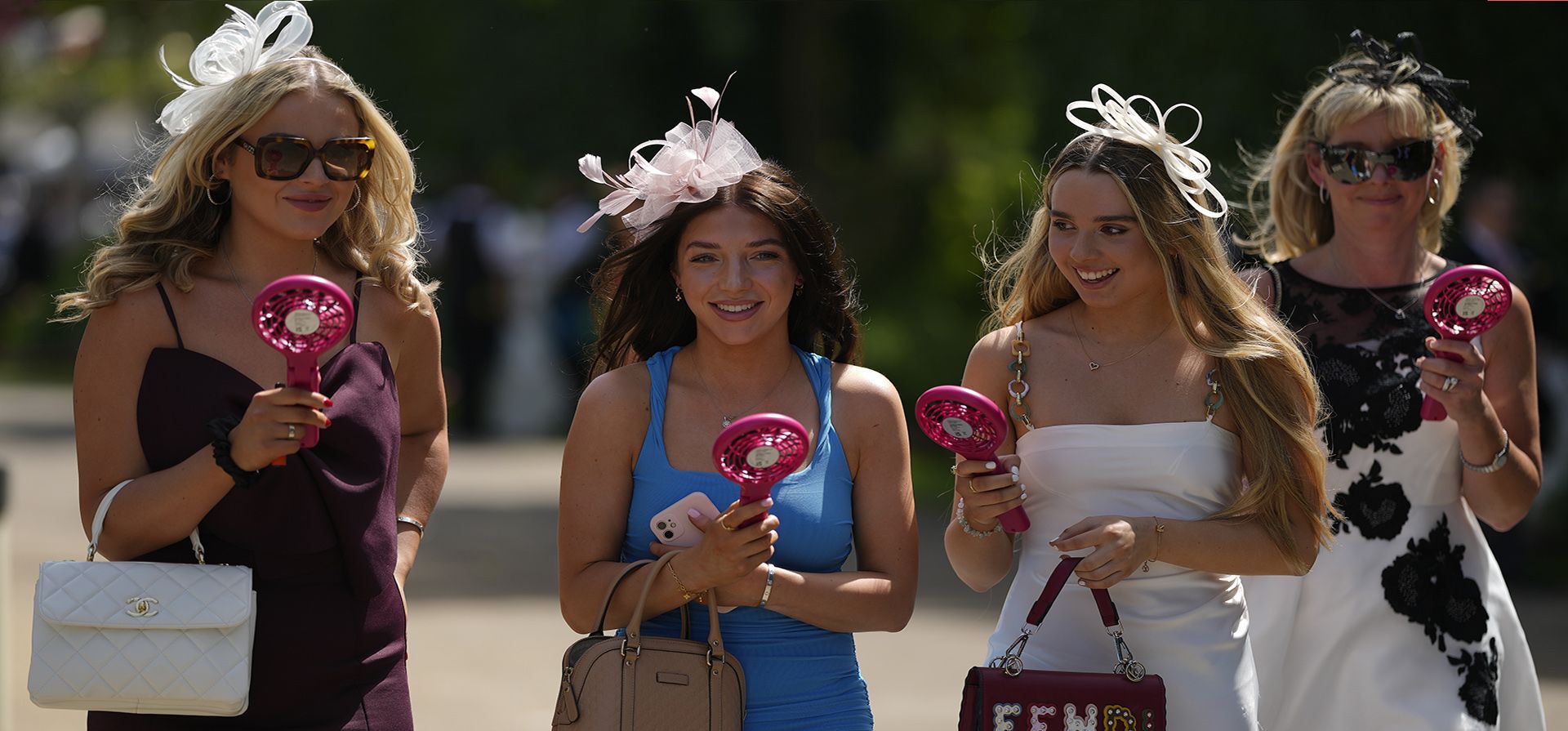 Asistentes a la carrera con ventiladores portátiles para refrescarse llegan al cuarto día de la carrera de caballos Royal Ascot, en el hipódromo de Ascot, en Ascot, Inglaterra, el viernes 24 de junio de 2022.