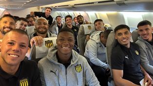 Los futbolistas de Peñarol sonríen arriba del chárter que transportó al plantel de Montevideo a Rosario.