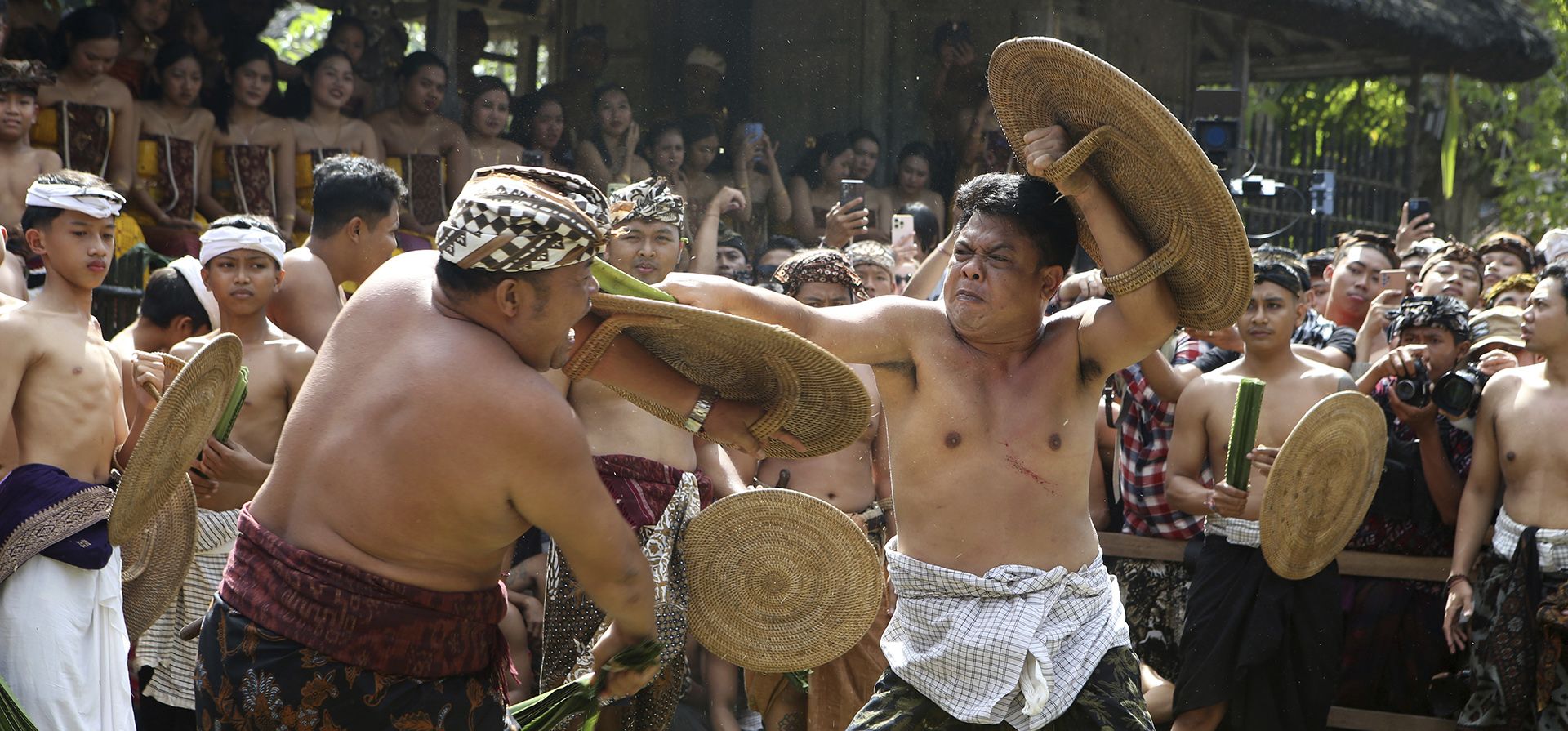 Dos hombres balineses luchan entre sí usando pandanus atados y espinosos y escudos durante el ritual llamado guerra de pandanus 'Mekare-kare' en la aldea de Tenganan en Bali, Indonesia, el miércoles 5 de junio de 2024. (Foto AP/Firdia Lisnawati) Dos hombres balineses luchan entre sí usando pandanus atados y espinosos y escudos durante el ritual llamado guerra de pandanus 'Mekare-kare' en la aldea de Tenganan en Bali, Indonesia, el miércoles 5 de junio de 2024. (Foto AP/Firdia Lisnawati)